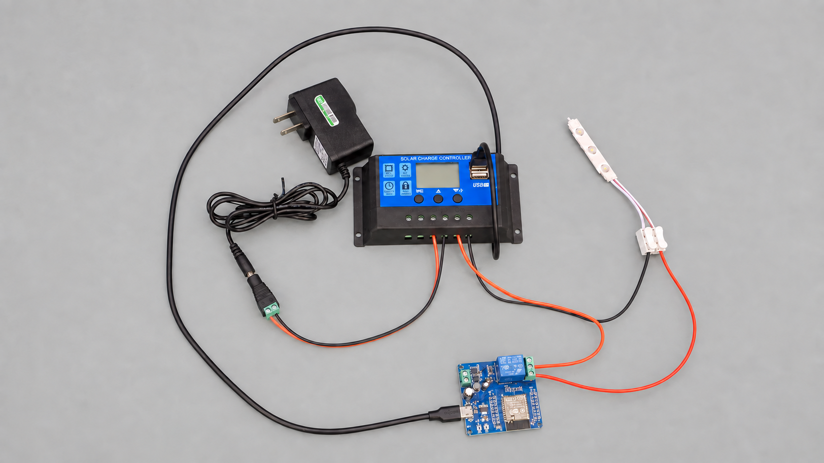 ตัวอย่างวงจรที่ต่อหลอด LED เสร็จแล้ว: อะแดปเตอร์ 12V ต่อเข้าคู่แบตเตอรี่ของ charge controller แทนแบตเตอรี่ สายบวกจากคู่โหลดของ charge controller เข้า COM ของบอร์ดรีเลย์ แล้วออกจาก NO ไปแผงต่อสายสีขาว สายลบจากคู่โหลดไปแผงต่อสายโดยตรง หลอด LED ต่อออกจากแผงต่อสาย บอร์ดรีเลย์รับไฟจากช่อง USB ของ charge controller ทางสาย USB-C