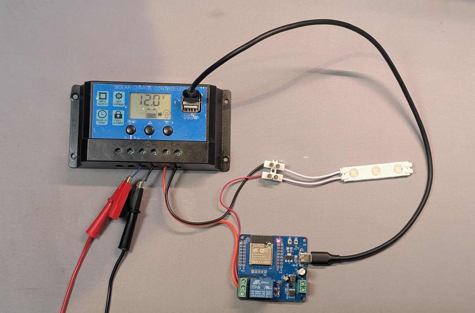 ชุดอุปกรณ์ของการอบรม: โซลาร์ชาร์จคอนโทรลเลอร์แสดง 12.0V ต่อกับบอร์ดรีเลย์และหลอด LED